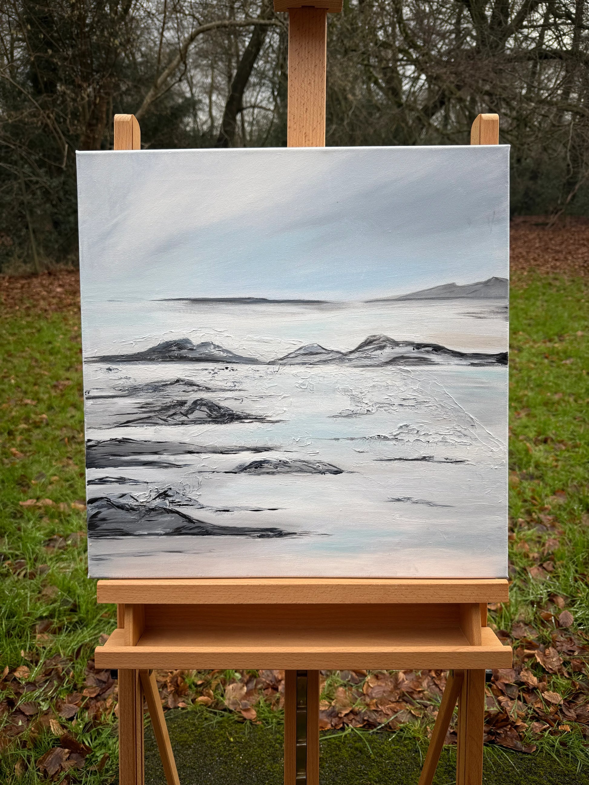 Romantic landscape oil painting of a tranquil lagoon with soft sky and rocky shoreline on canvas.