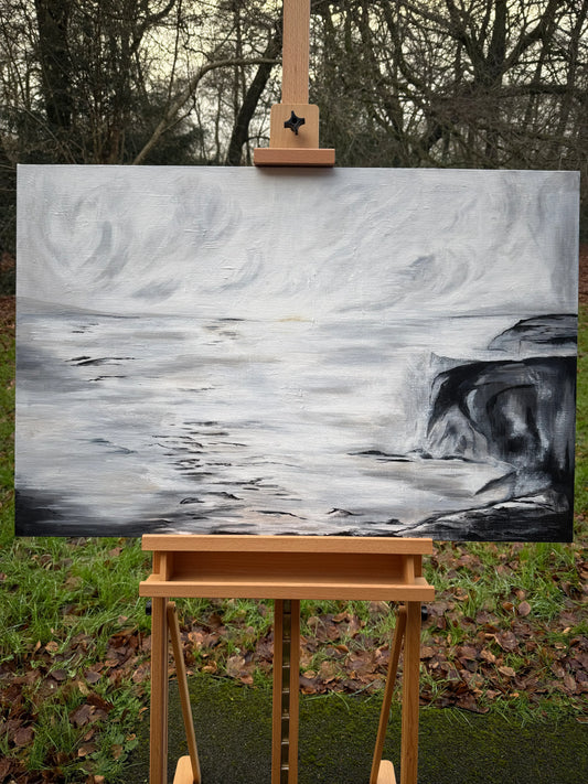 Monochrome seascape oil painting on easel, depicting stormy cliffs and swirling clouds.