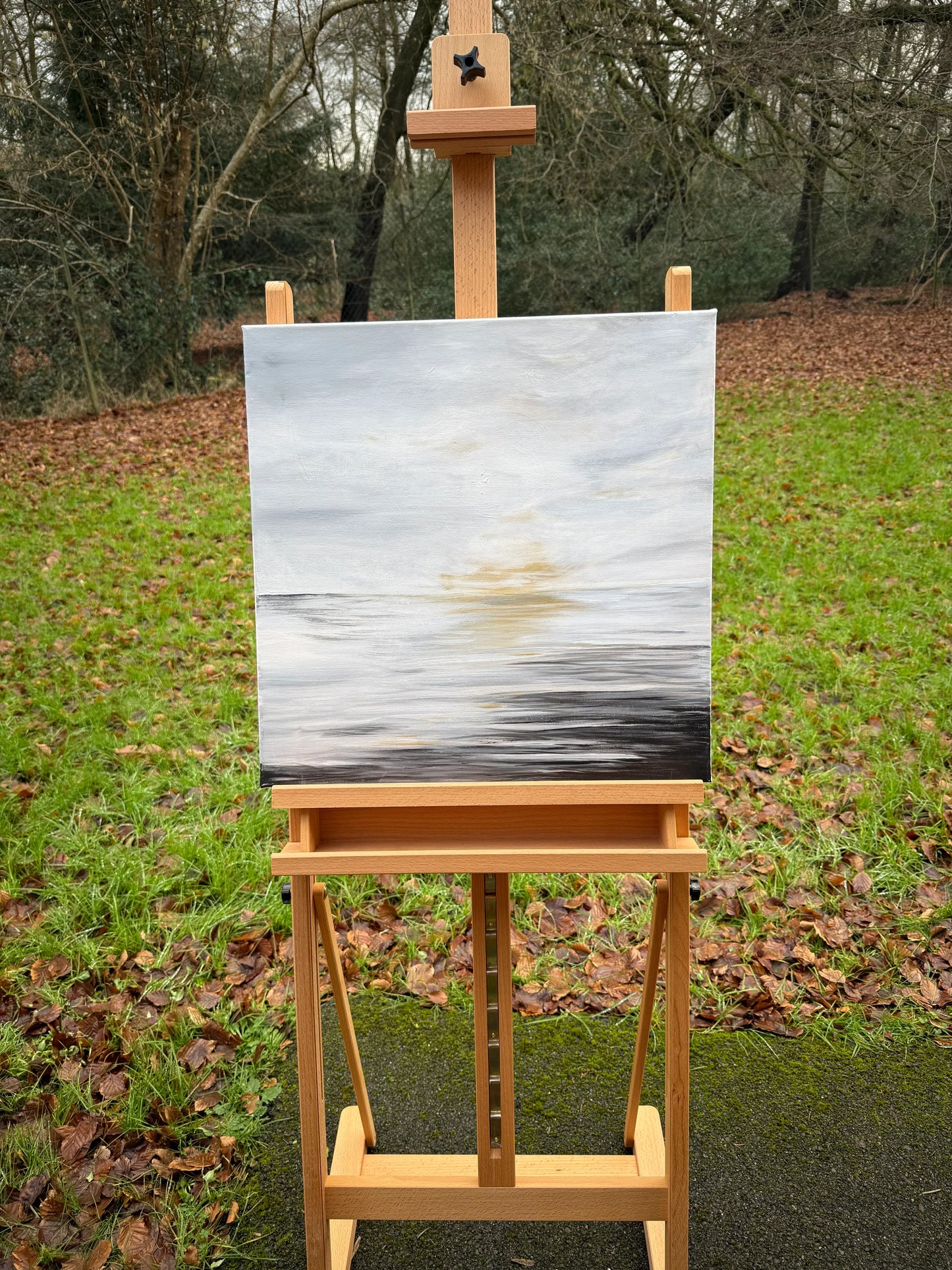 Abstract sunrise oil painting on easel outdoors, soft sky and water reflections, nature art