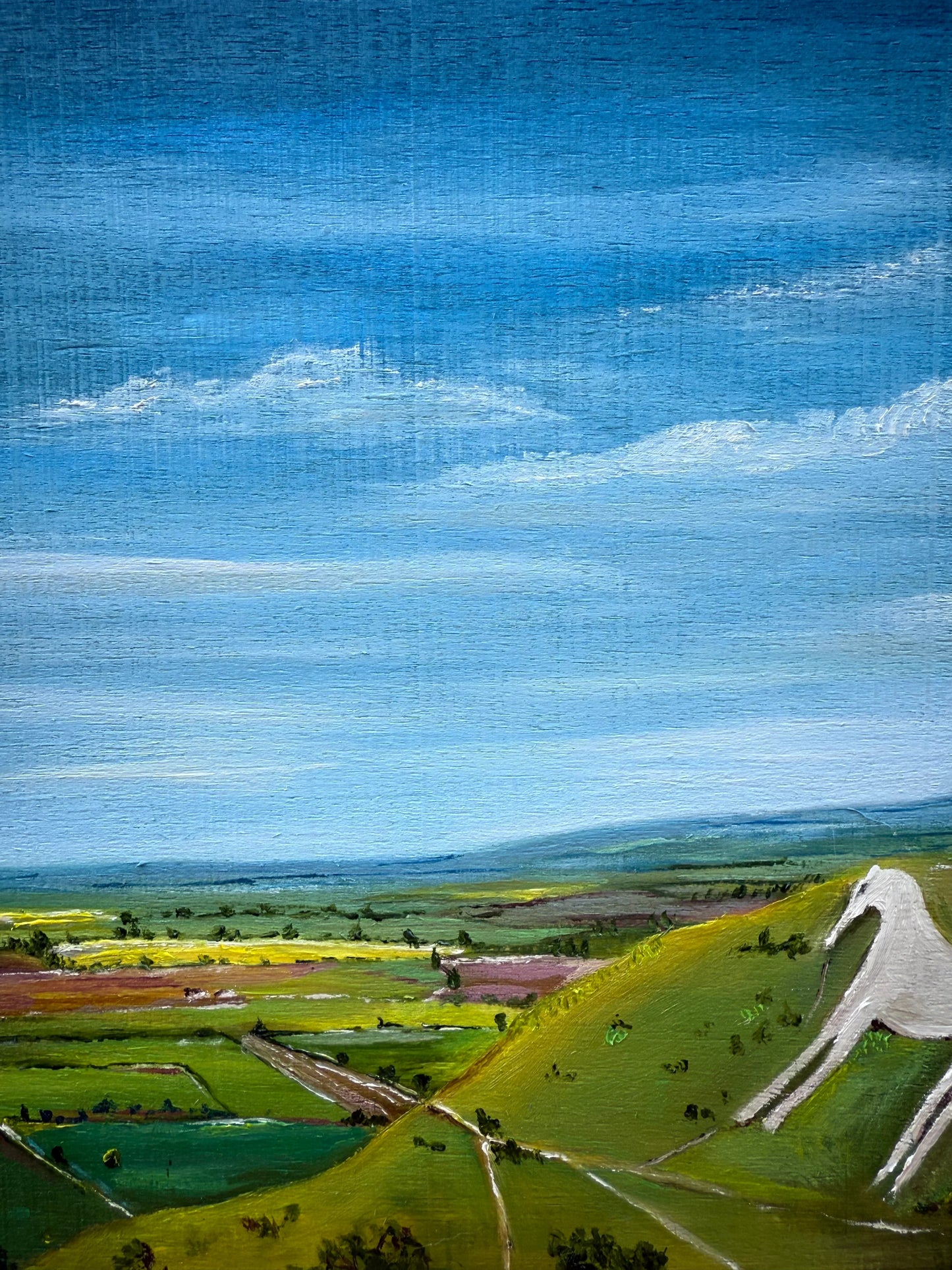 Oil painting of Westbury White Horse on a green hillside under a blue sky with fields.